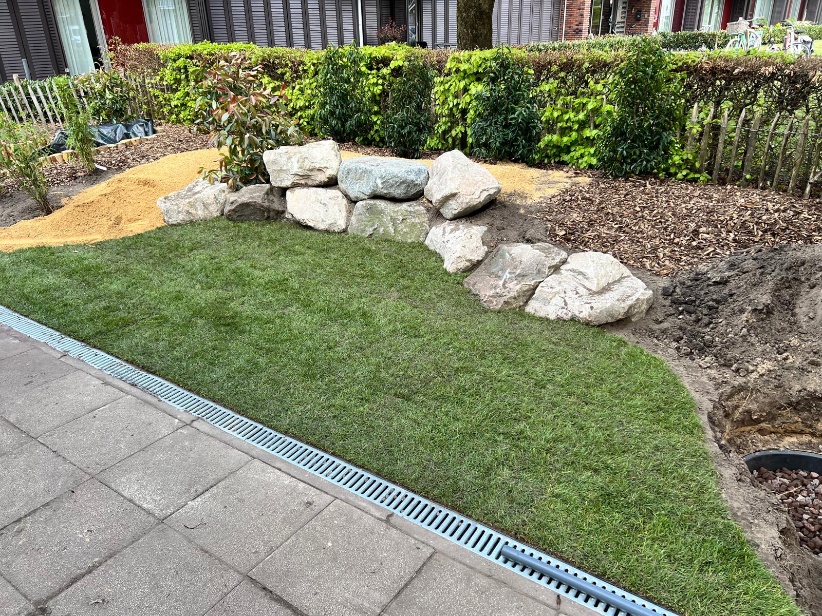 Tuin met natuurstenen keien, strak gazon en beplanting aangelegd door Sterk in Groen Exclusief